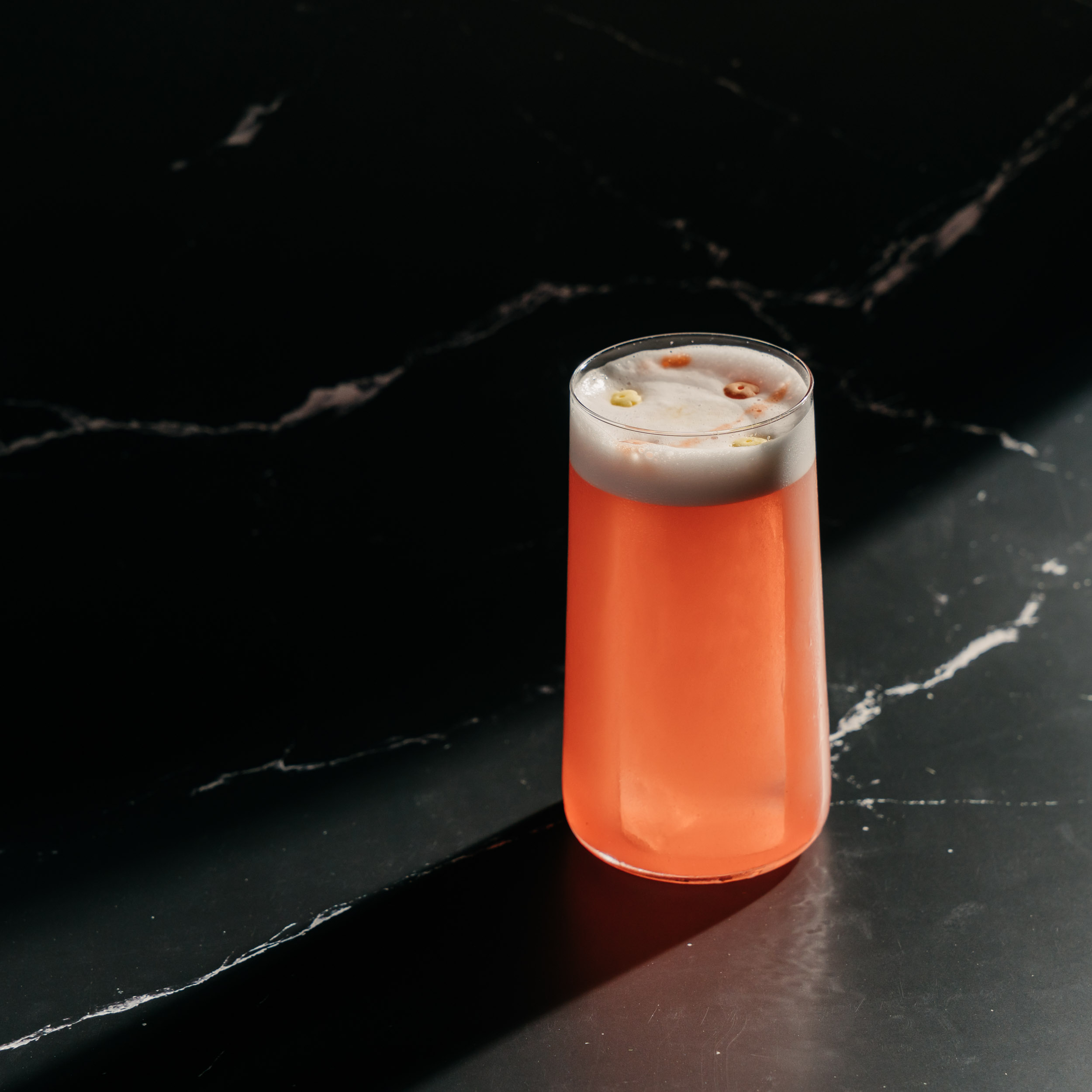 A photo of a cocktail on black marble background